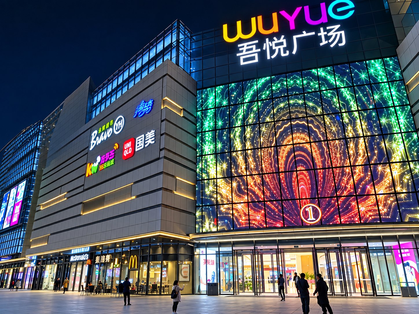 Shopping complex with a full-height LED media façade lit at night