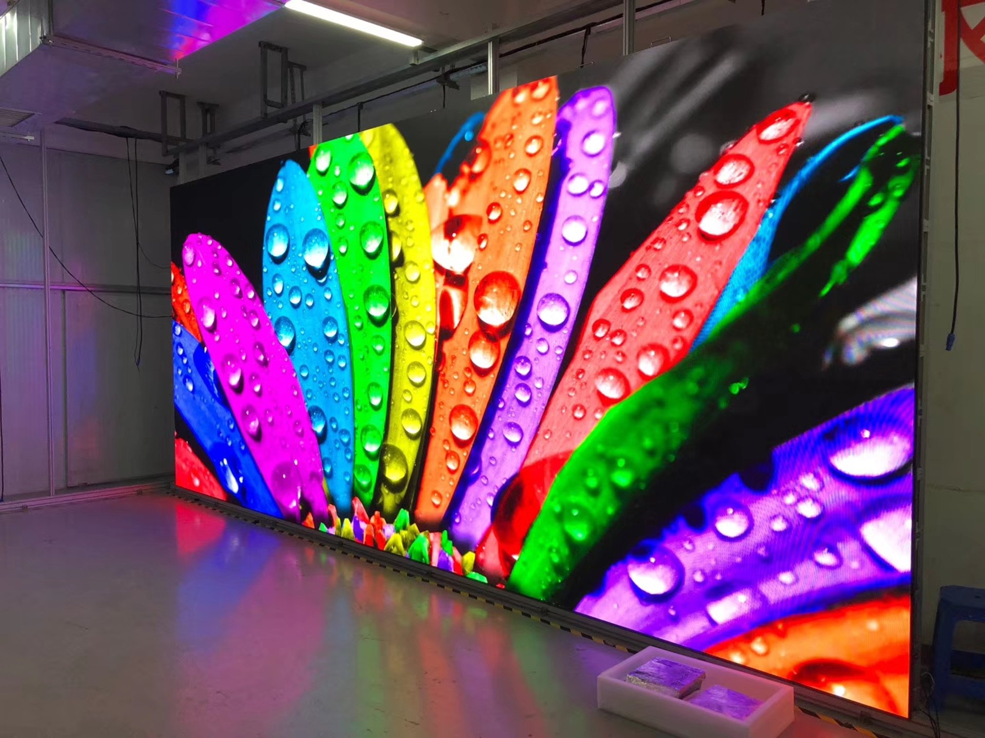 Large LED video wall in the factory showing vivid water-drop artwork with rich color reproduction