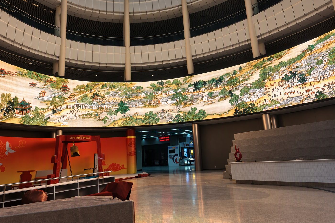 Sweeping curved indoor LED wall wrapping an exhibition atrium